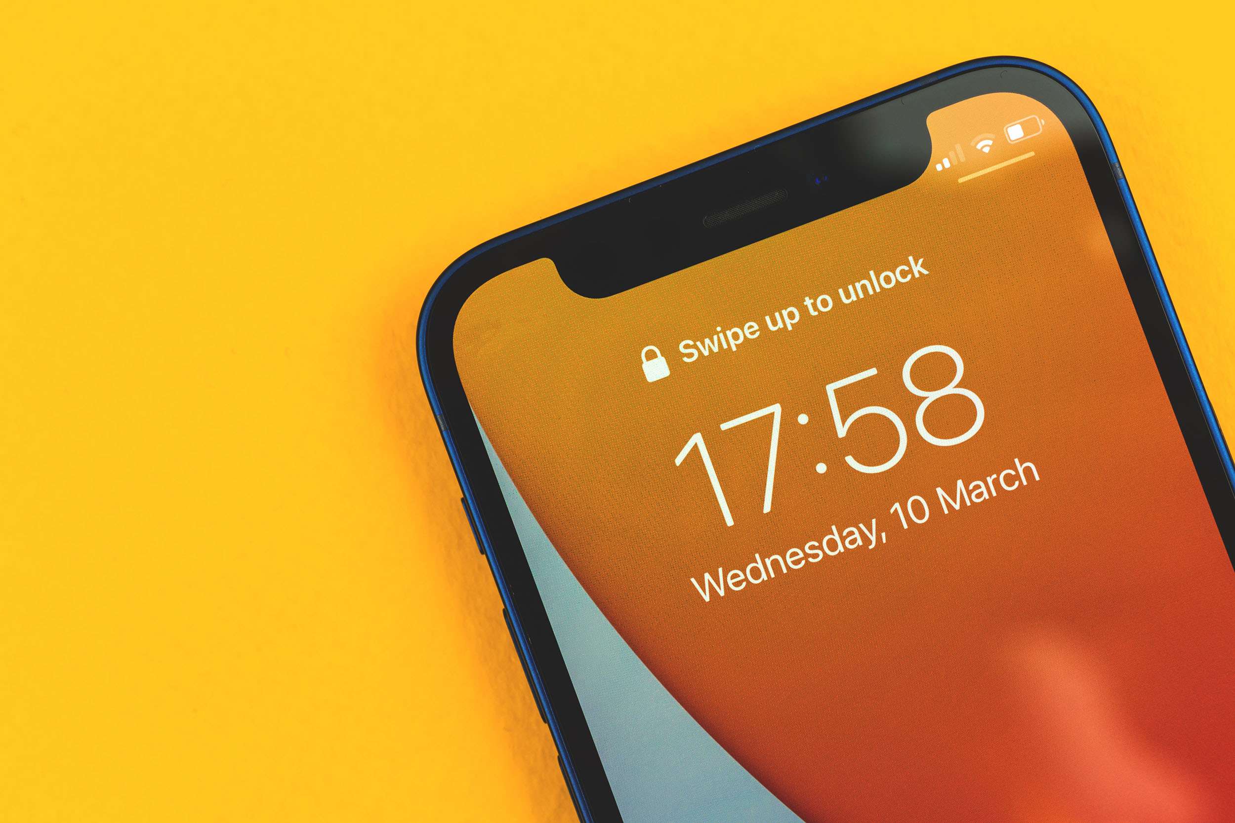 Kharkov, Ukraine - March 10, 2021: Apple iPhone with lockscreen, swipe to unlock message text
